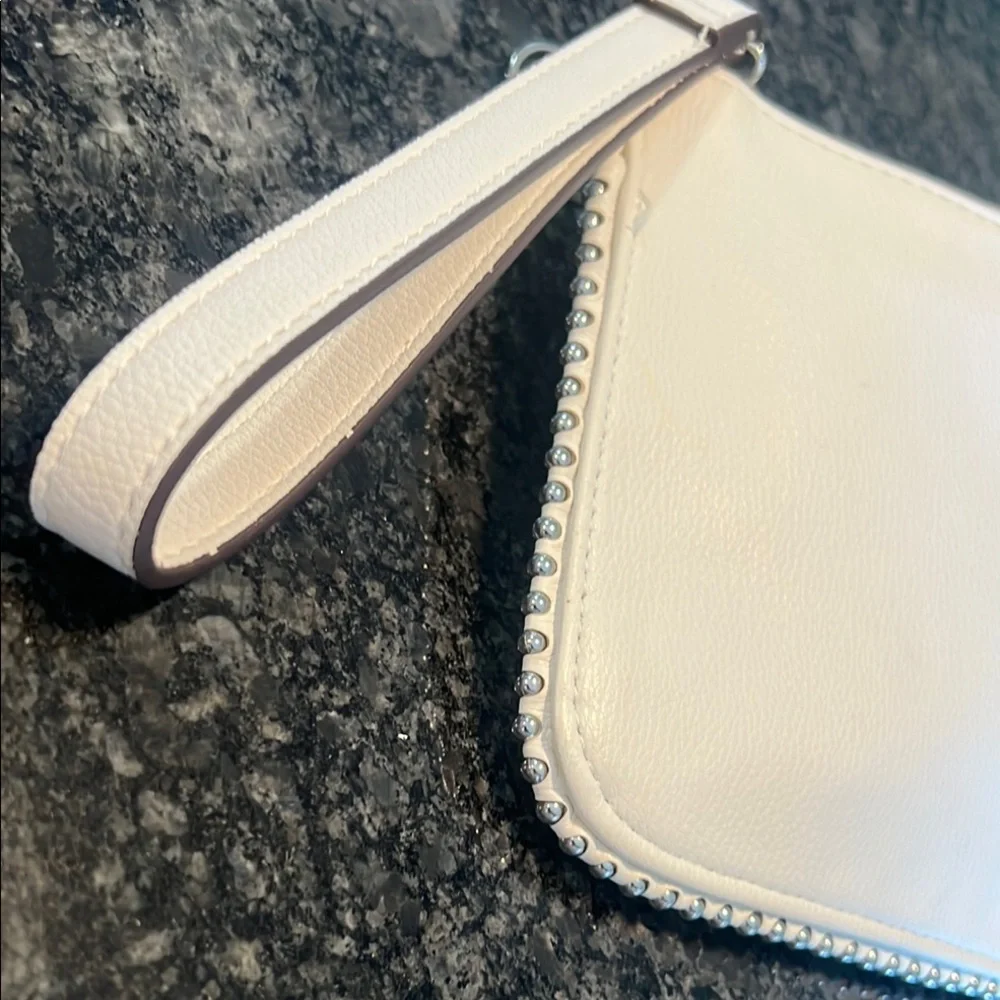 Carlos Santana White Textured Wristlet with Zipper Closure and rose medal accent